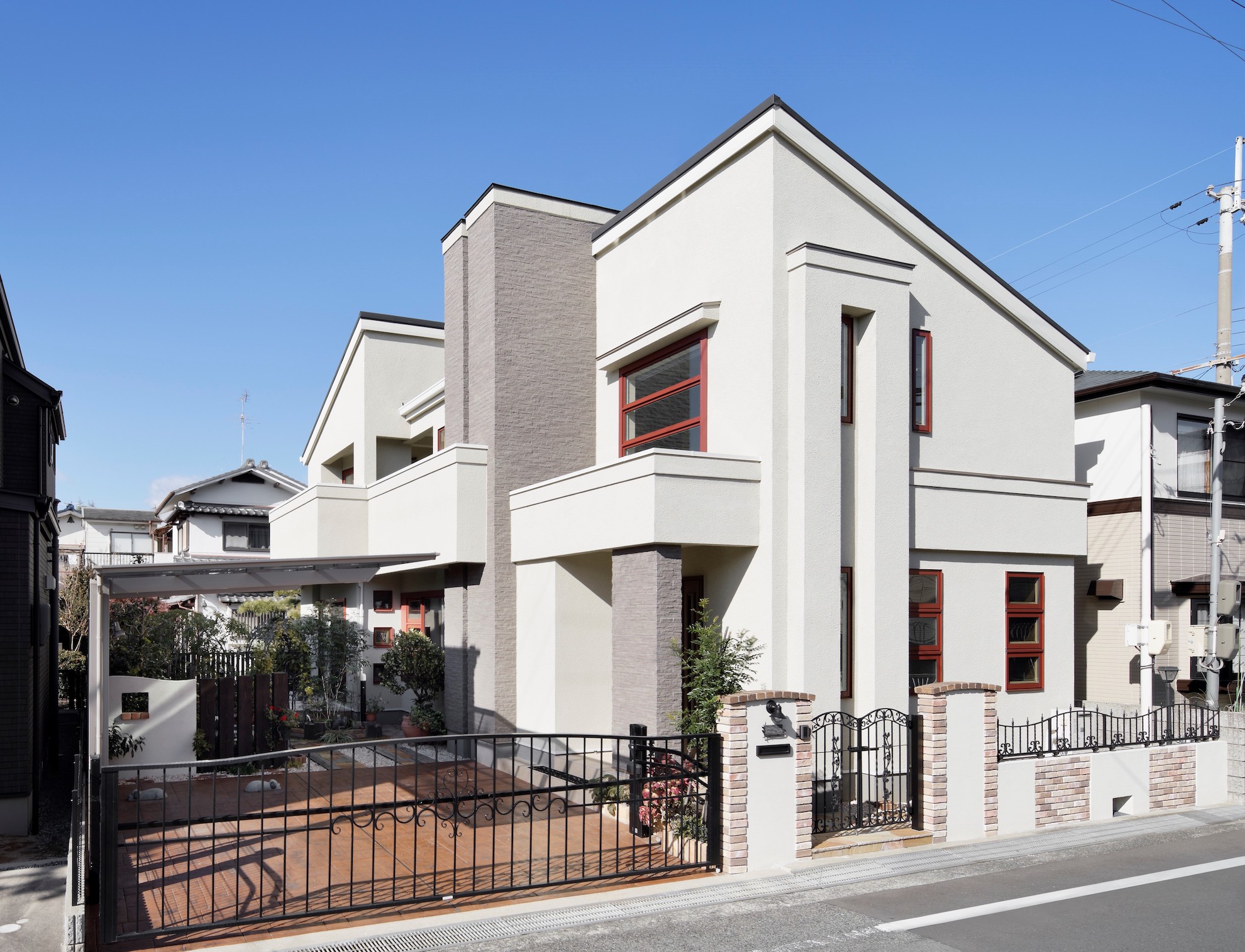 白い外壁にウィンドウトリムの赤茶色が映える家